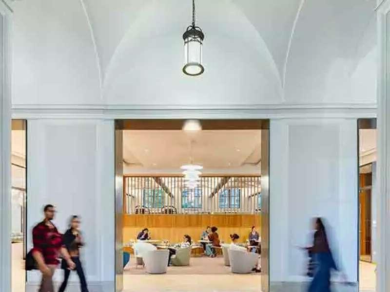 Francine LeFrak Center lobby, an airy space with light-green and blue furniture, with people strolling by